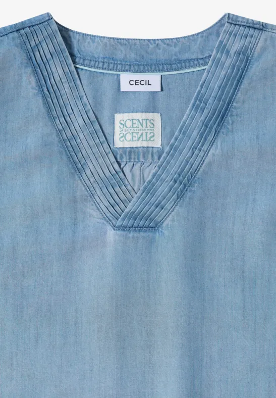 Lichtblauw denim topje met V-hals en fijne stiksels langs de kraag.