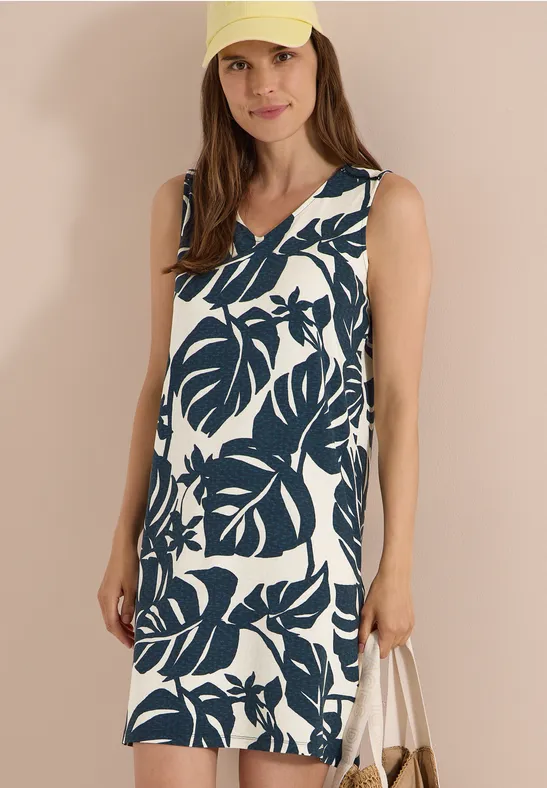 Ärmelloses knielanges Sommerkleid mit V-Ausschnitt und großem dunkelgrünem Blättermuster auf Weiß.