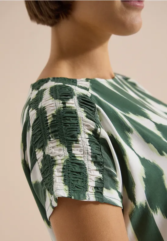 Nahaufnahme eines grün-weißen Batik-Shirts mit Schulterraffung