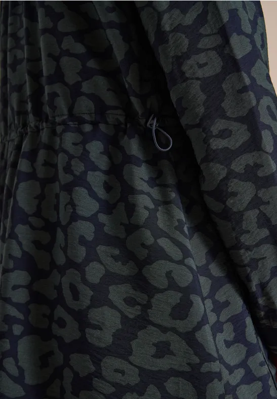 Dunkelgrüne Jacke mit schwarzem Animal-Print-Muster und Kordelzug in der Taille.