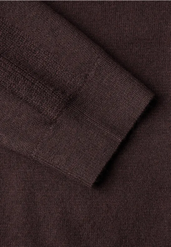 Nahaufnahme eines braunen Strickpullovers mit feiner Maschenstruktur.