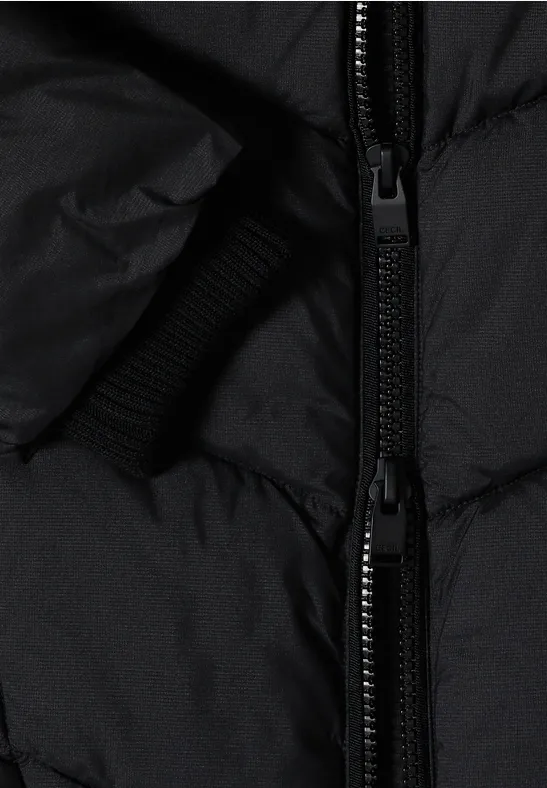 Nahaufnahme einer schwarzen Steppjacke mit Doppelreißverschluss und elastischem Bündchen