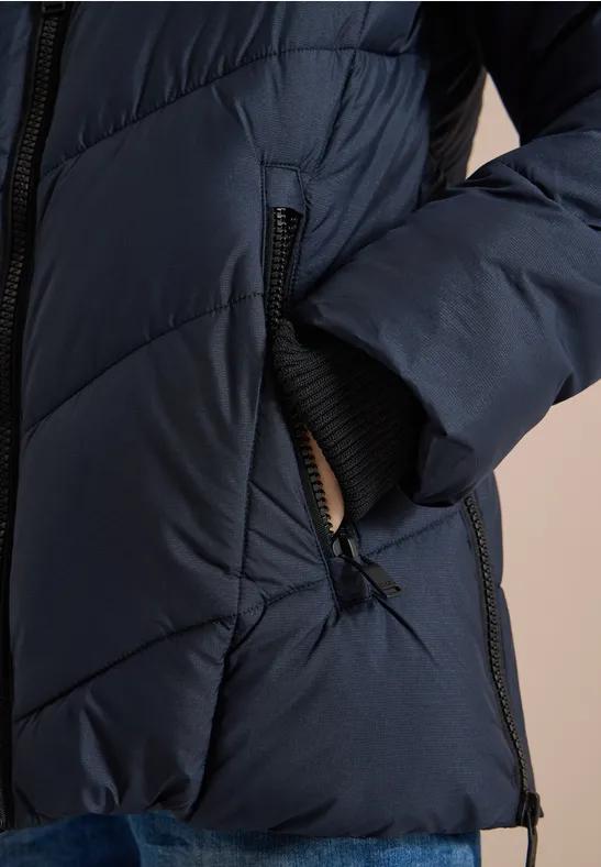 Dunkelblaue, gesteppt gepolsterte Jacke mit Reißverschluss, seitlicher Tasche und elastischem Ärmelbündchen.