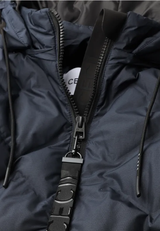 Nahaufnahme einer dunkelblauen Steppjacke mit Reißverschluss und einem schwarzen Riemen mit Schnalle.