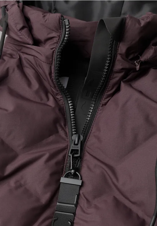 Nahaufnahme eines Reißverschlusses an einer dunkellila Jacke.