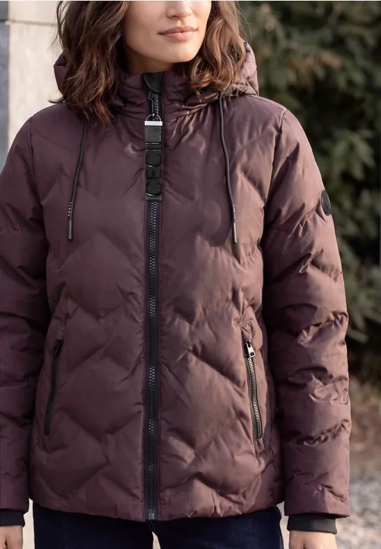 Frau trägt gesteppte, dunkelbraune Winterjacke mit Kapuze.