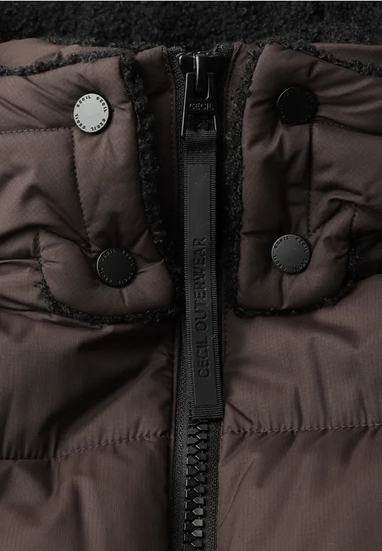 Nahaufnahme einer braunen Daunenjacke mit Reißverschluss und Druckknöpfen am Kragen.
