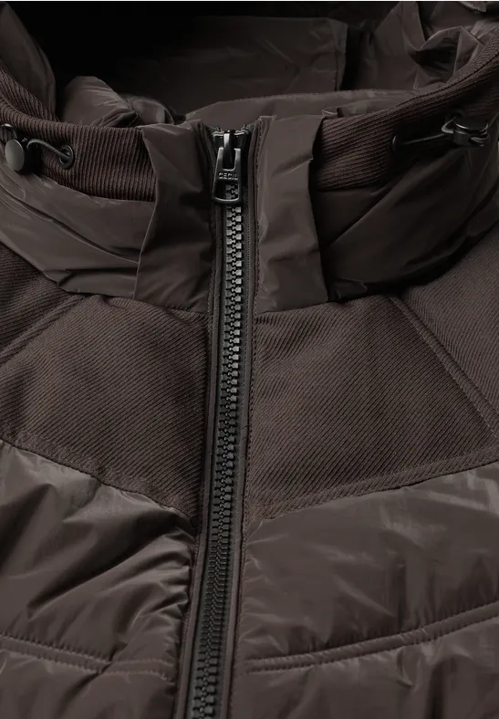 Braune Jacke mit mittigem Reißverschluss und Steppmuster, Nahaufnahme des Oberteils.