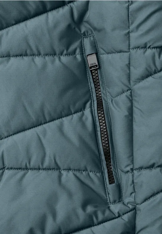 Grüne gesteppte Jacke mit Reißverschluss-Tasche in Nahaufnahme.