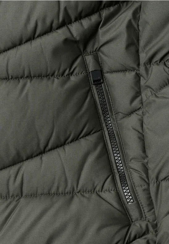 Nahaufnahme einer olivgrünen, gesteppten Jacke mit senkrechter Reißverschlusstasche.