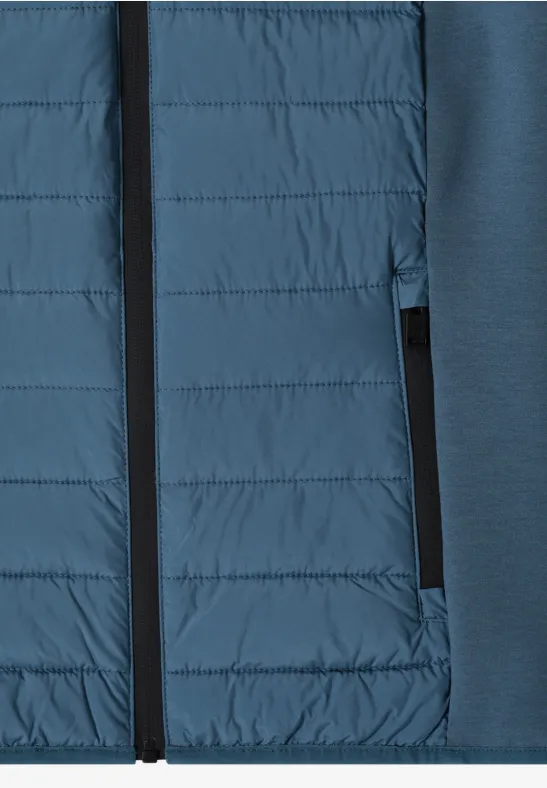 Nahaufnahme einer blauen Hybridjacke mit gesteppter Front und Reißverschlusstasche.