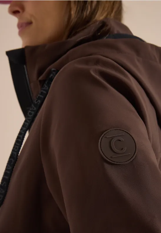 Braune Jacke mit Reißverschluss und rundem Logo am Ärmel.