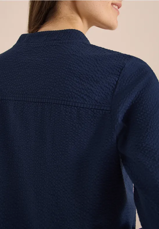 Nahaufnahme einer Frau von hinten in einem dunkelblauen, texturierten Langarmshirt