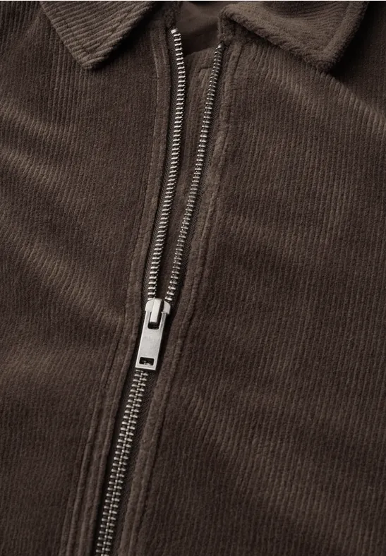 Nahaufnahme einer braunen Cordjacke mit halb geöffnetem Reißverschluss