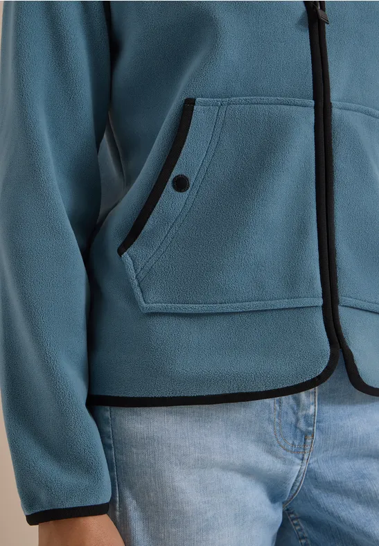 Blauer Kapuzenpullover mit schwarzen Kanten und Tasche, dazu Jeans