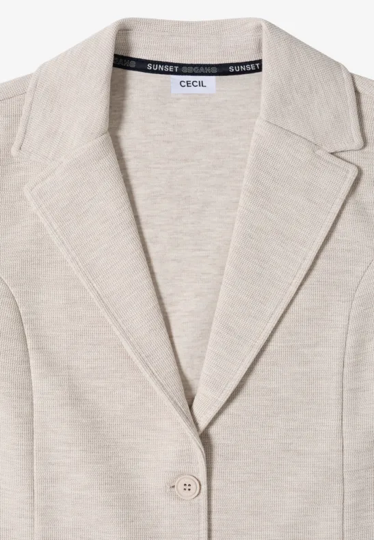 Blazer en jersey beige à col châle et fermeture boutonnée.