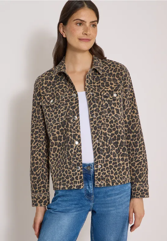 Frau trägt weiße Bluse, blaue Jeans und eine braune Jacke mit Leopardenmuster.