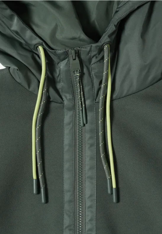 Nahaufnahme einer dunkelgrünen Jacke mit Reißverschluss und olivgrünen Kordeln an der Kapuze
