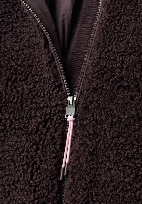Nahaufnahme eines dunklen Fleece-Reißverschlusses mit schwarzem Einsatz und pinkem Zipperzug.