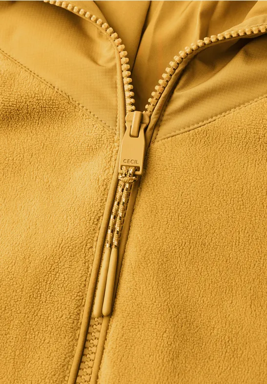 Nahaufnahme eines gelben Fleecejacken-Reißverschlusses mit zwei Zipper-Pulls.