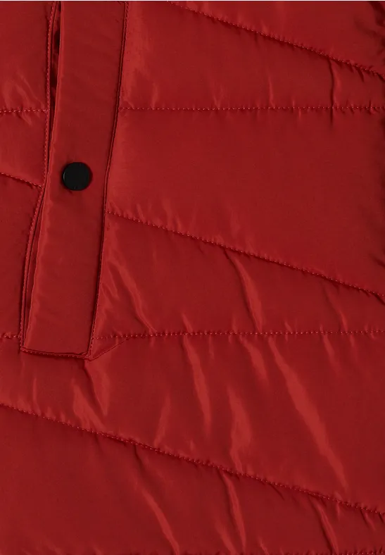 Manteau d'hiver matelassé rouge à coutures diagonales et bouton noir.