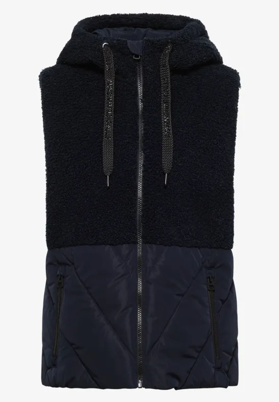 Gilet sans manches bleu foncé avec haut en polaire Teddy, bas matelassé, capuche et fermeture éclair.