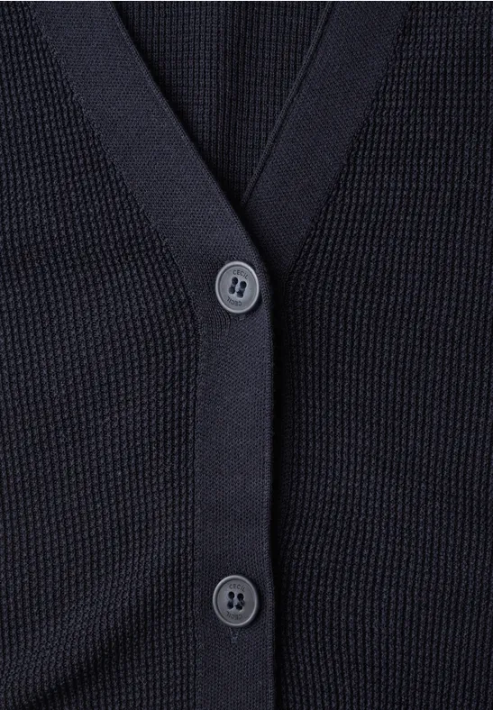 Nahaufnahme eines dunkelblauen Strickcardigans mit V-Ausschnitt und Knöpfen