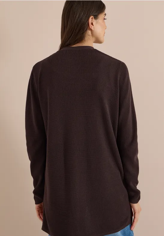 Frau von hinten in locker sitzendem, langärmeligen, dunkelbraunen Pullover.