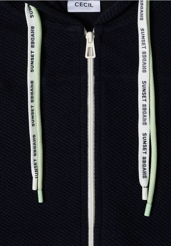 Schwarzer Hoodie mit weißem Reißverschluss und weißen Kordeln mit grünem "SUNSET BOARD"-Schriftzug.