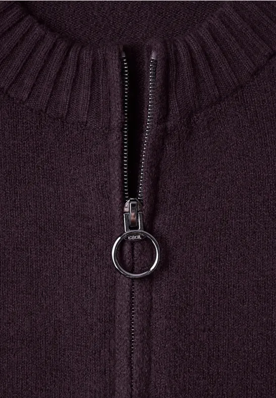 Nahaufnahme eines dunkelvioletten Strickstoffs mit Reißverschluss und ringförmigem Metallzipper.
