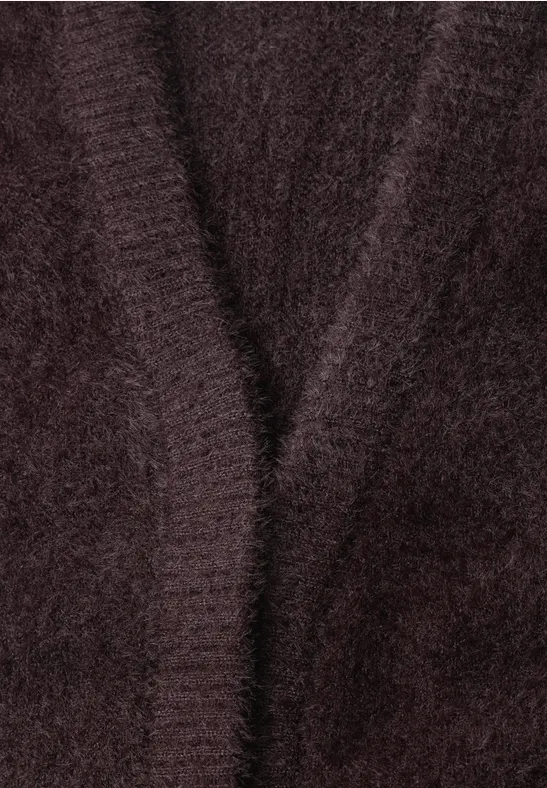 Nahaufnahme eines flauschigen, dunklen Strickstücks mit dezentem V-Ausschnitt