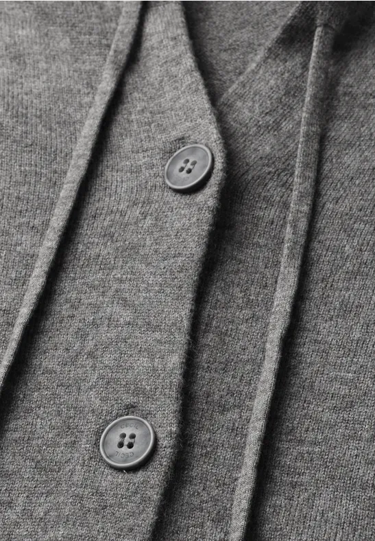 Gros plan sur un tissu gris avec deux boutons.