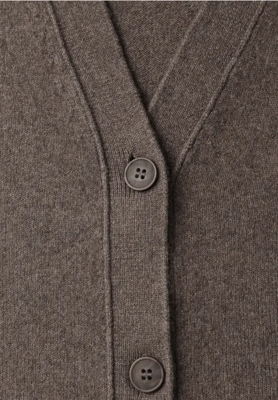 Nahaufnahme eines braunen Strickcardigans mit V-Ausschnitt und zwei großen Knöpfen.