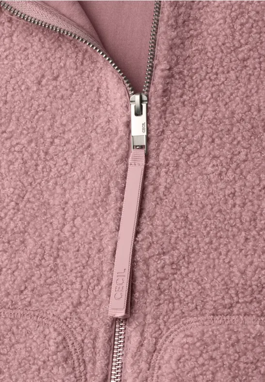 Nahaufnahme einer rosa Teddy-Fleecejacke mit silbernem Reißverschluss und Zipperzug.