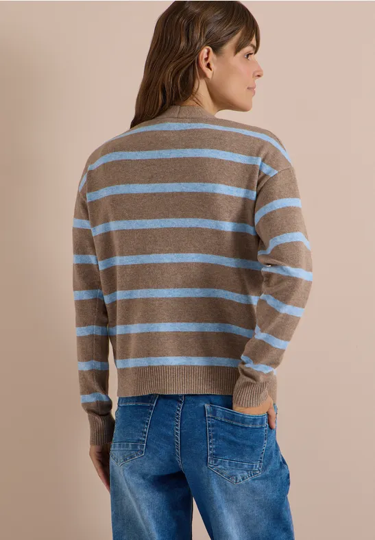 Frau von hinten in braun-blau gestreiftem Pullover und Jeans.