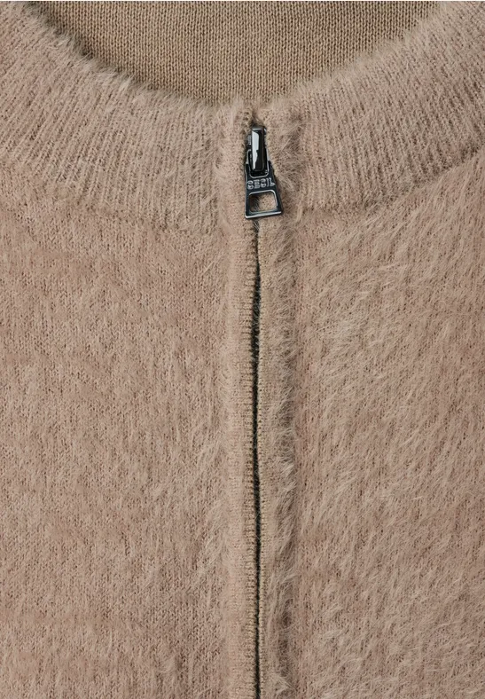 Beige, flauschiger Strickpullover mit silbernem Reißverschluss bis zum Rundhalsausschnitt.