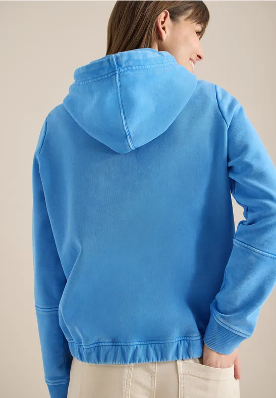 Vue de dos d’une personne portant un sweat à capuche bleu clair