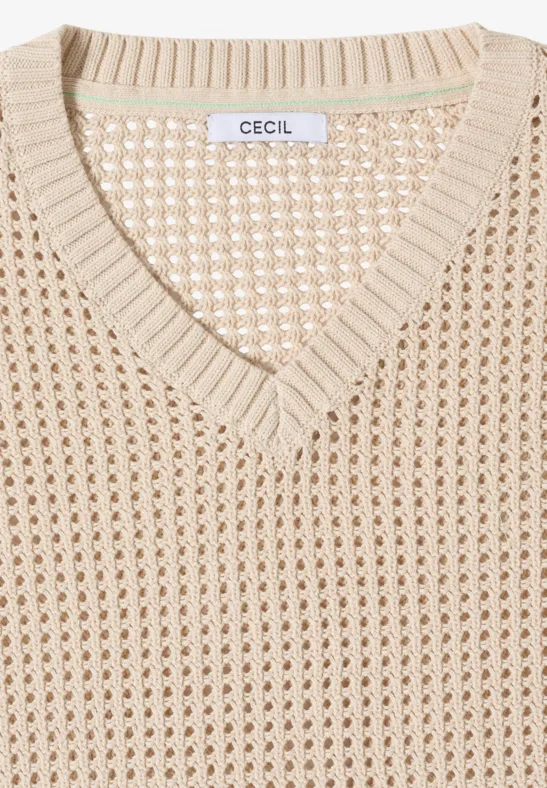 Opgevouwen beige gebreide trui met V-hals en open motief, merklabel "CECIL" bij de kraag.