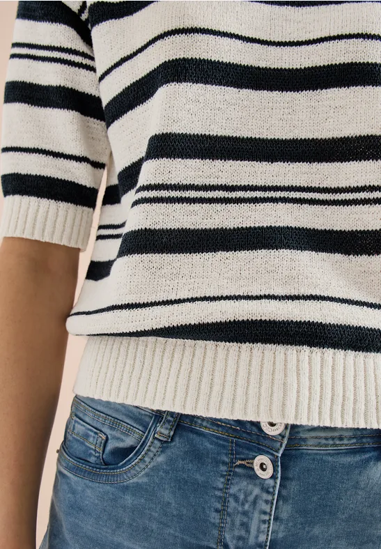 Torso in weiß-schwarzem Streifenpullover und blauer Jeanshose