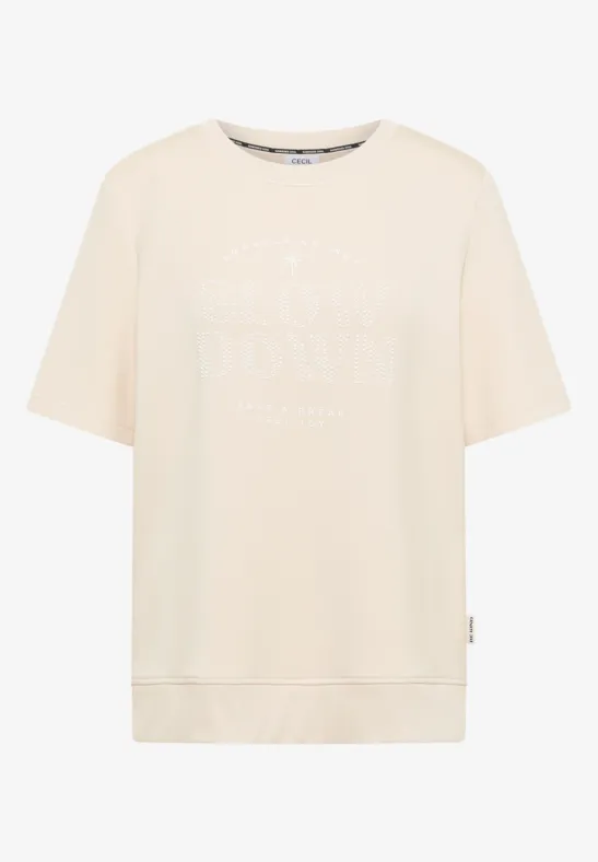 Beiges T-Shirt mit weitem Schnitt und dezentem weißen Logo-Schriftzug vorne.