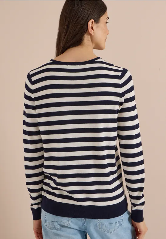 Frau von hinten in maritim gestreiftem Langarmpullover (Marine/Weiß) und Jeans.