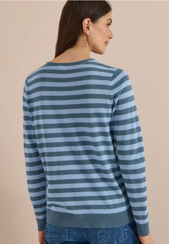 Frau von hinten in blau-gestreiftem Pullover und Jeans.