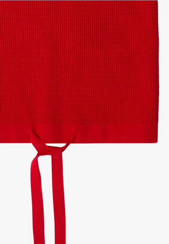 Rotes gestricktes Textil mit zwei Bändern, wirkt wie eine Schürze.