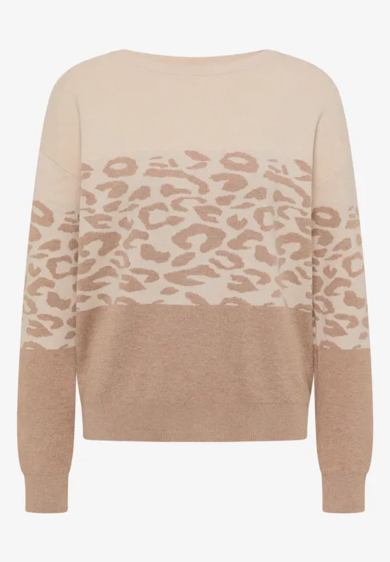 Beiger Pullover mit hellem Leo-Muster auf Brust und Ärmeln.