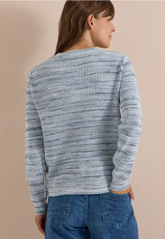 Vue de dos d’une femme portant un pull bleu clair mélangé et un jean décontracté.