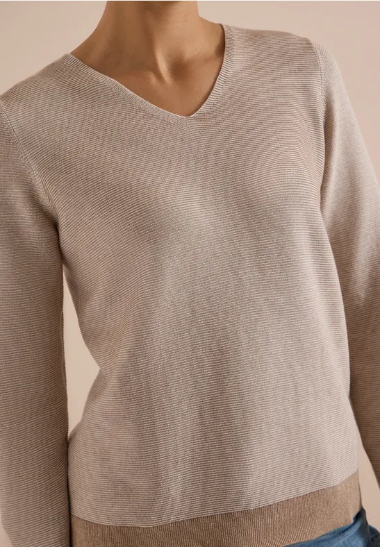 Pull beige à col V, manches longues, maille fine et design épuré.