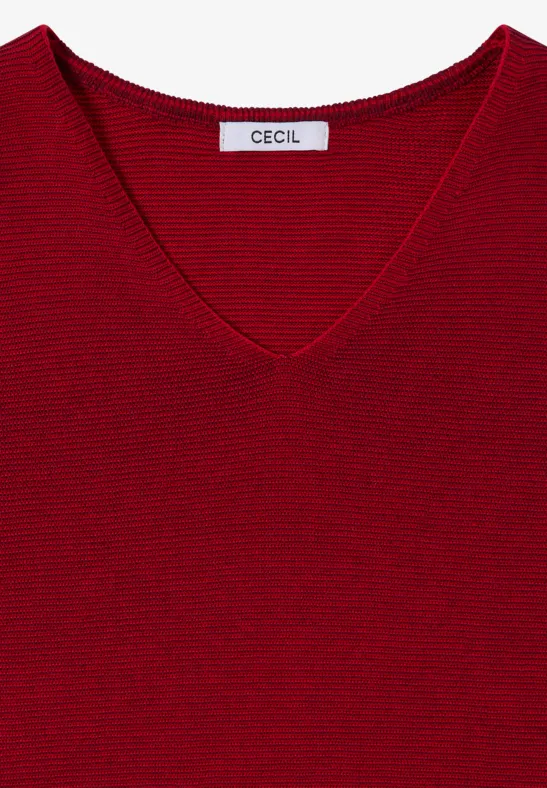 Un t-shirt rouge à col V à fines côtes avec l’étiquette 'CECIL'.