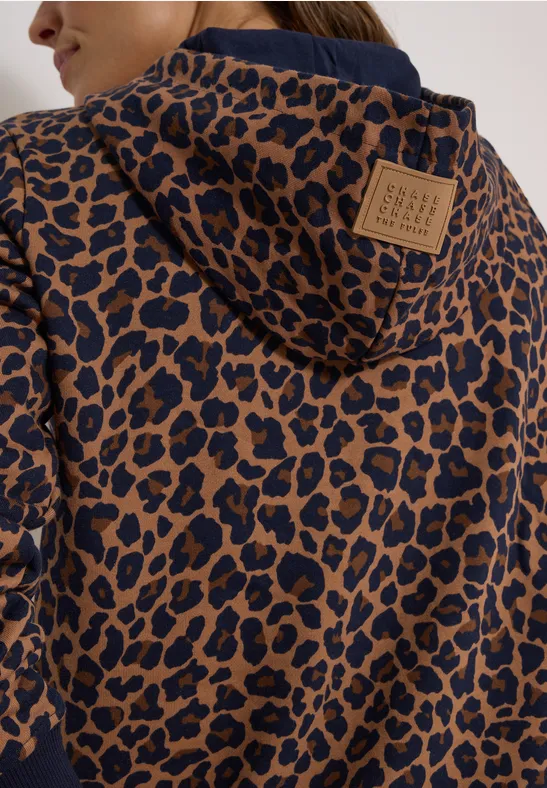 Rückenansicht einer Kapuzenjacke mit braun-schwarzem Leopardenmuster und Lederpatch am Kragen.
