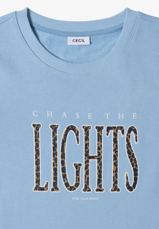 Hellblaues T-Shirt mit Aufdruck 'CHASE THE LIGHTS' in Leopardenmuster.
