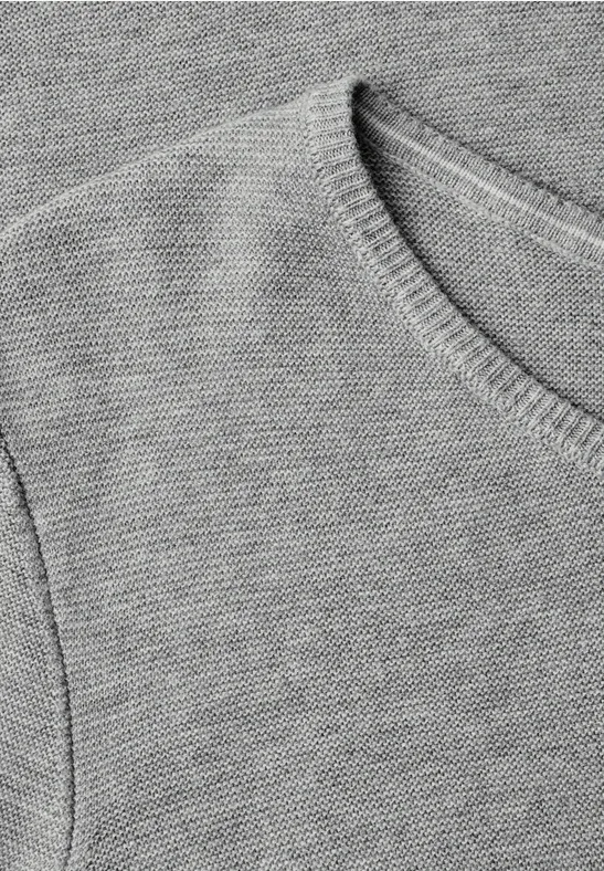 Close-up eines grauen Strickpullover-Oberteils mit Rundhalsausschnitt und feiner Rippung.